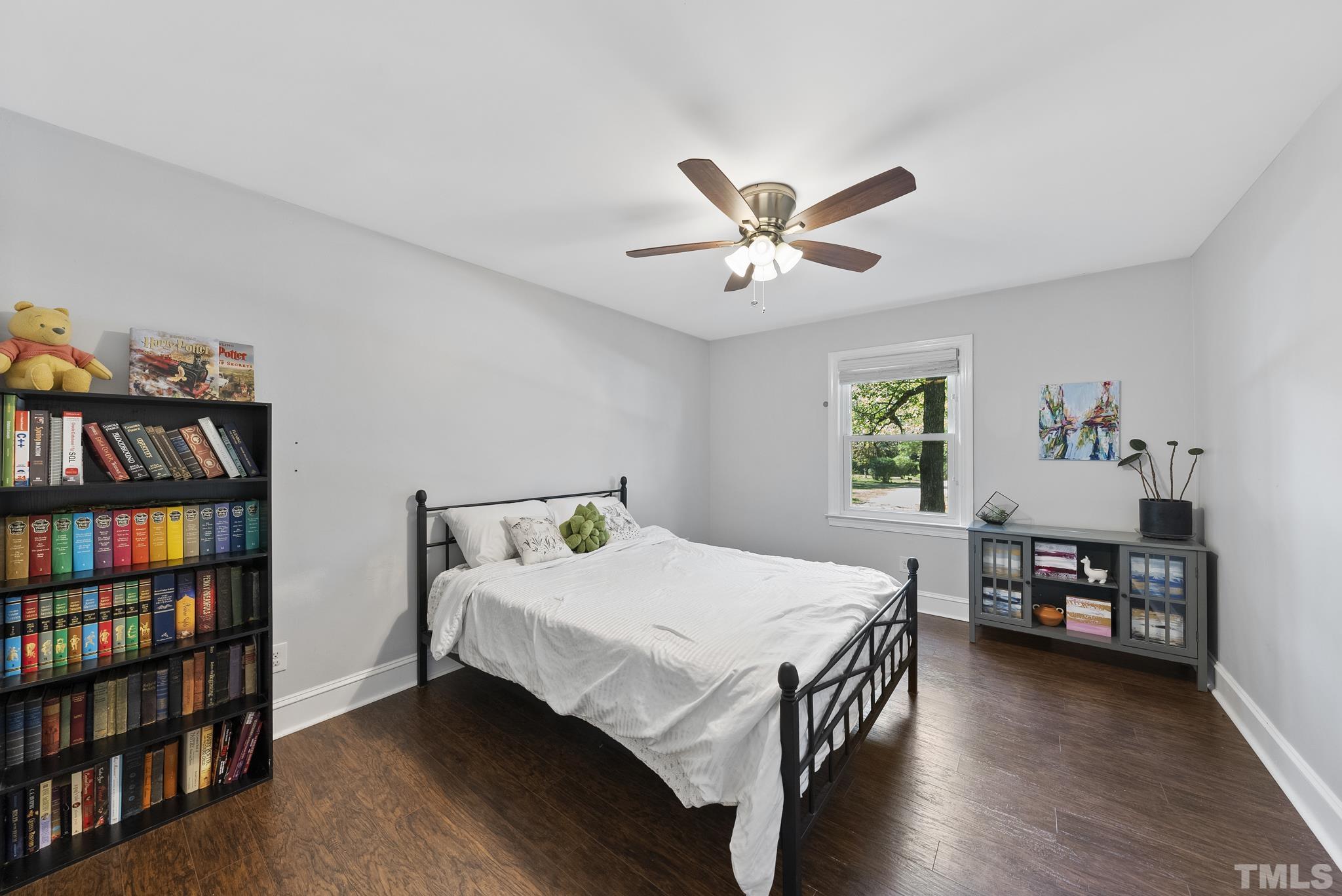 7516 Ray Road Raleigh, NC 27613 - Photo 12 of 23 a bedroom with a bed a book shelf and a window