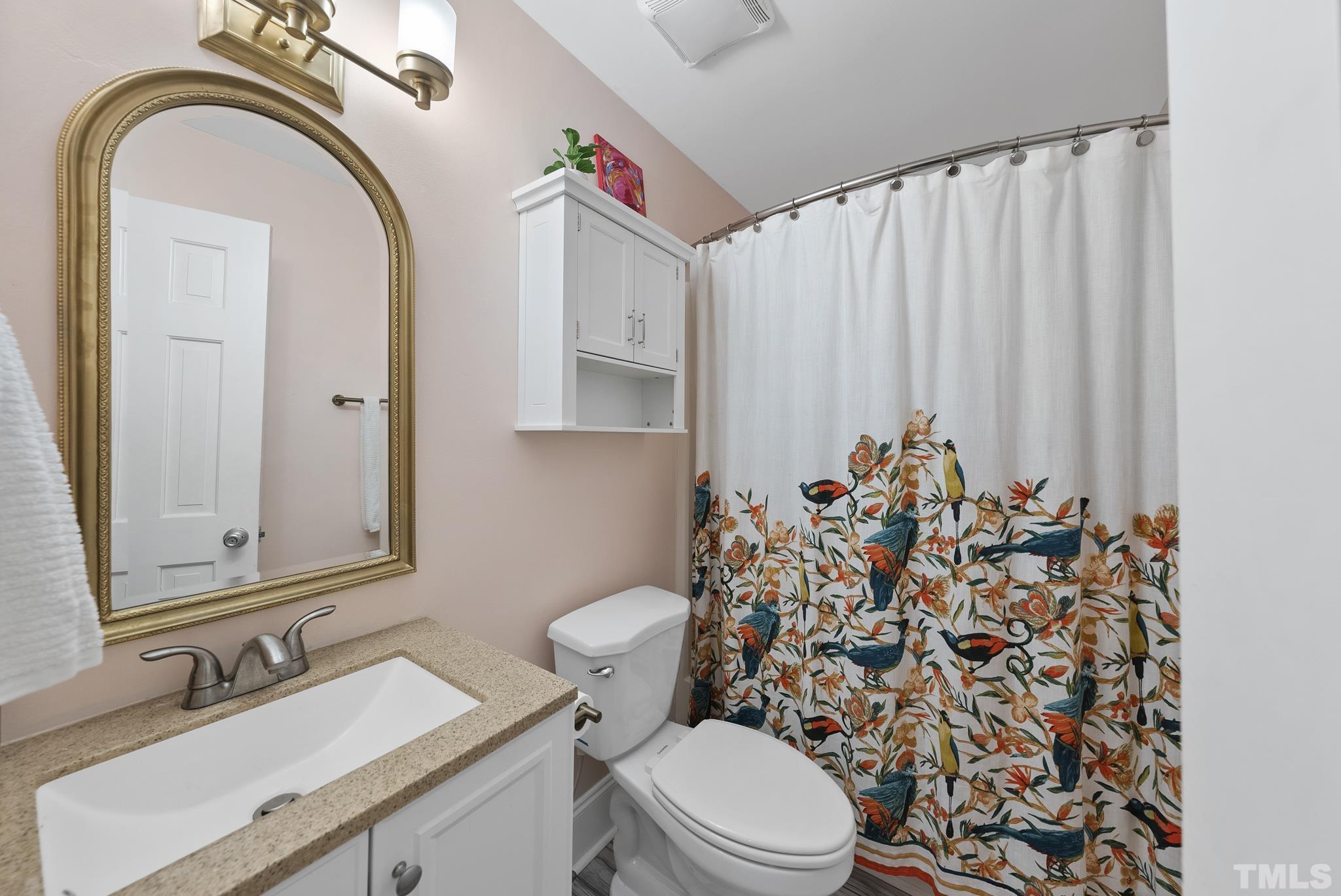 7516 Ray Road Raleigh, NC 27613 - Photo 13 of 23 a bathroom with a toilet sink and mirror