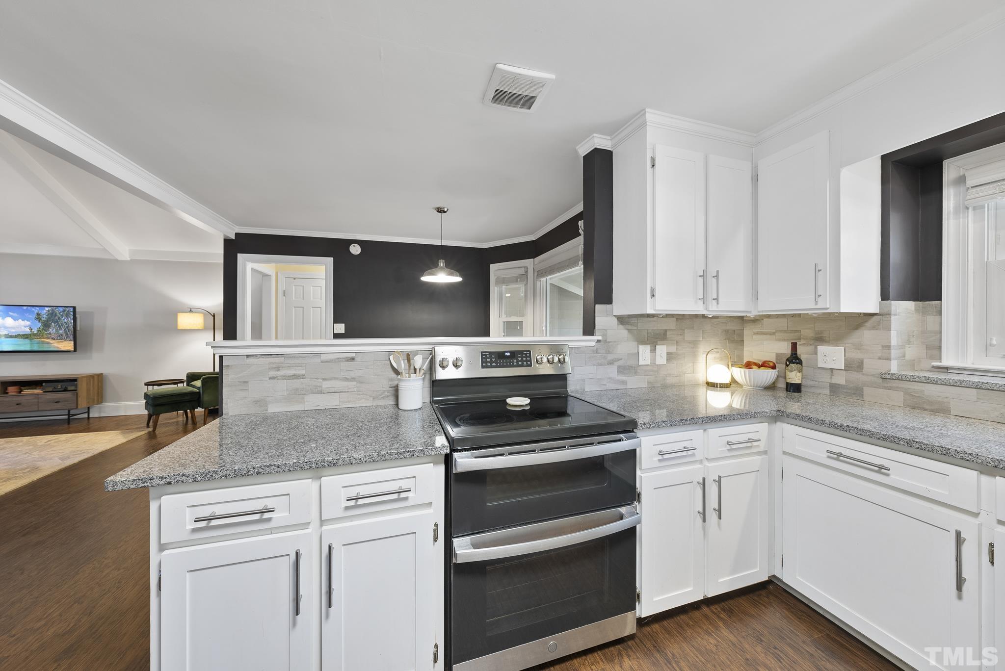 7516 Ray Road Raleigh, NC 27613 - Photo 5 of 23 a kitchen with granite countertop white cabinets and white appliances