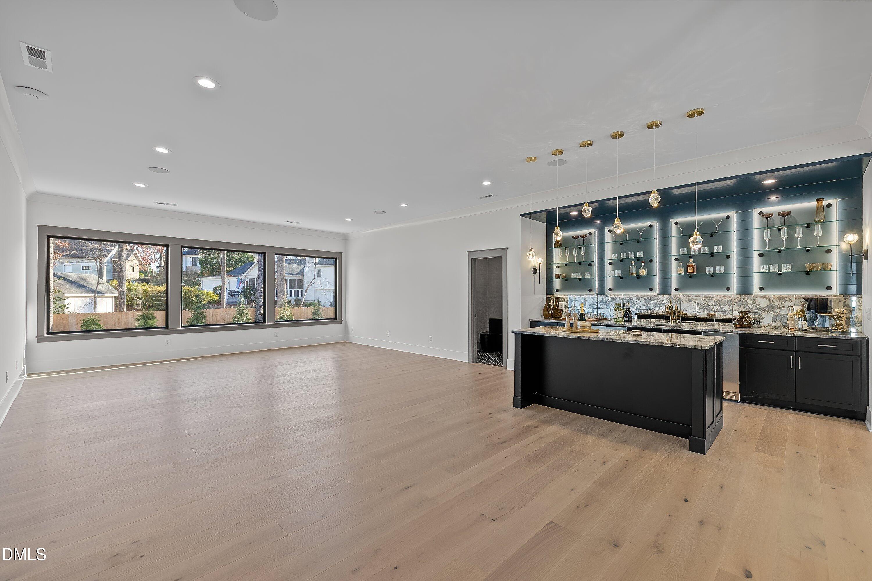1312 Hunting Ridge Road Raleigh, NC 27615 - Photo 61 of 95 a large living room with kitchen area and large windows