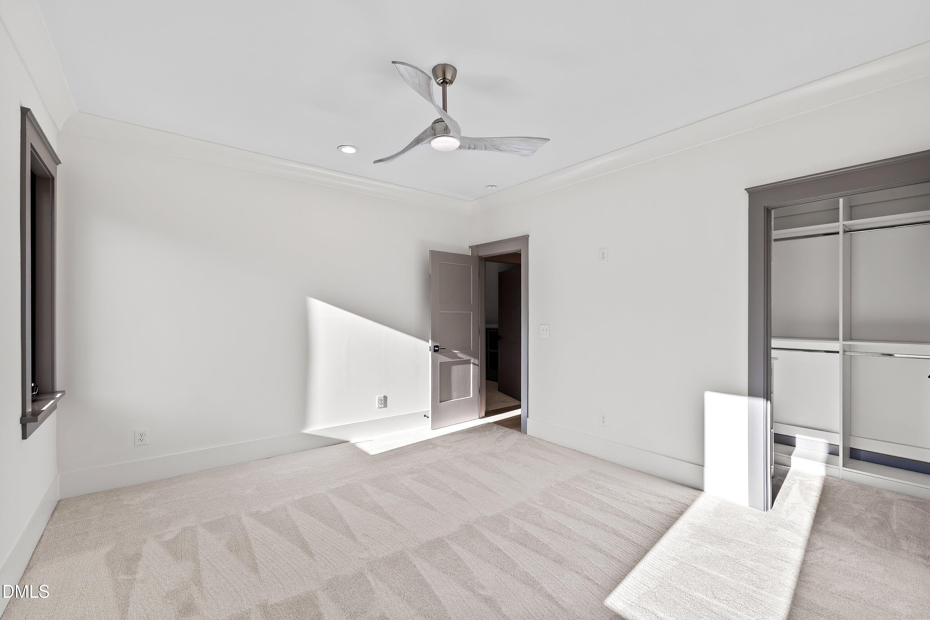 1312 Hunting Ridge Road Raleigh, NC 27615 - Photo 73 of 95 a view of an empty room with wooden floor and a ceiling fan