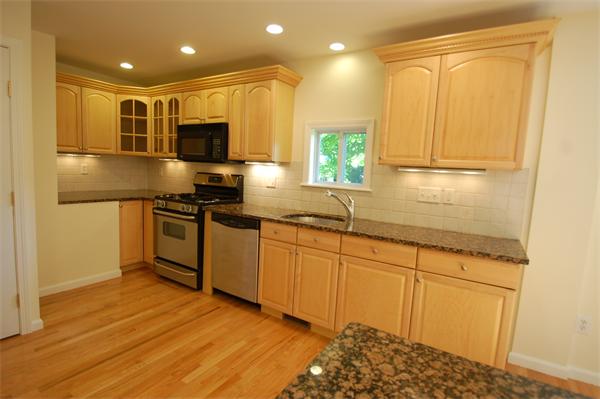 15 Woodland Road Wellesley, MA 02481 - Photo 2 of 5 a kitchen with stainless steel appliances granite countertop a sink a stove and a refrigerator