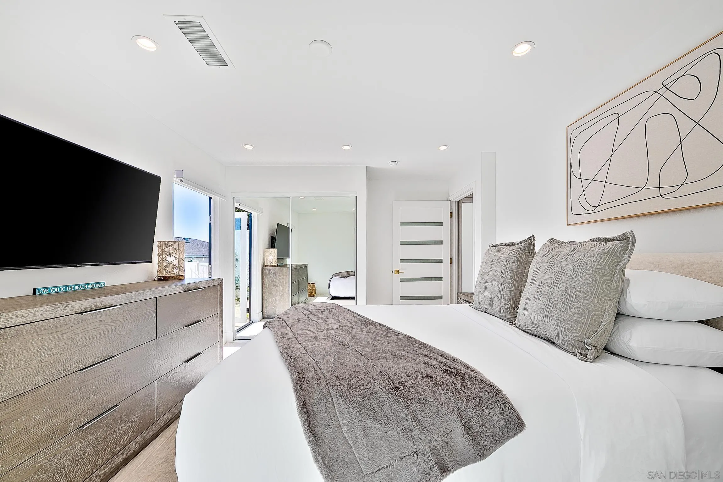 303 Sea Lane La Jolla, CA 92037 - Photo 35 of 61 a spacious bedroom with a bed and a flat screen tv