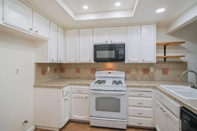 a kitchen with white cabinets stainless steel appliances and sink