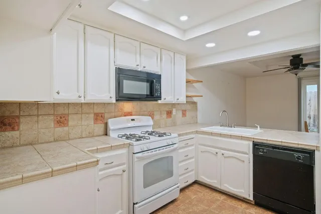 a kitchen with cabinets appliances a sink and a counter top space