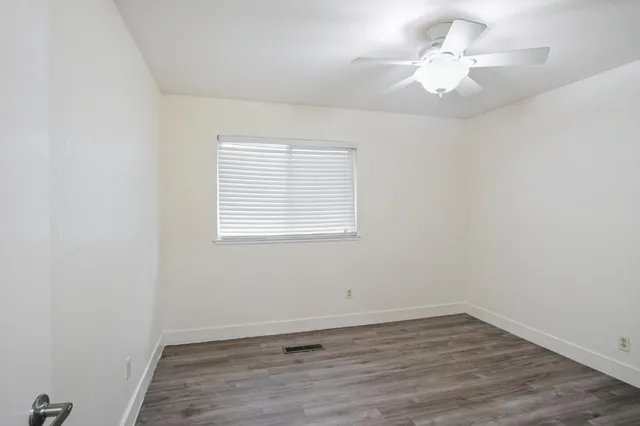 an empty room with wooden floor and window