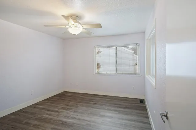 a view of a room with wooden floor and fan