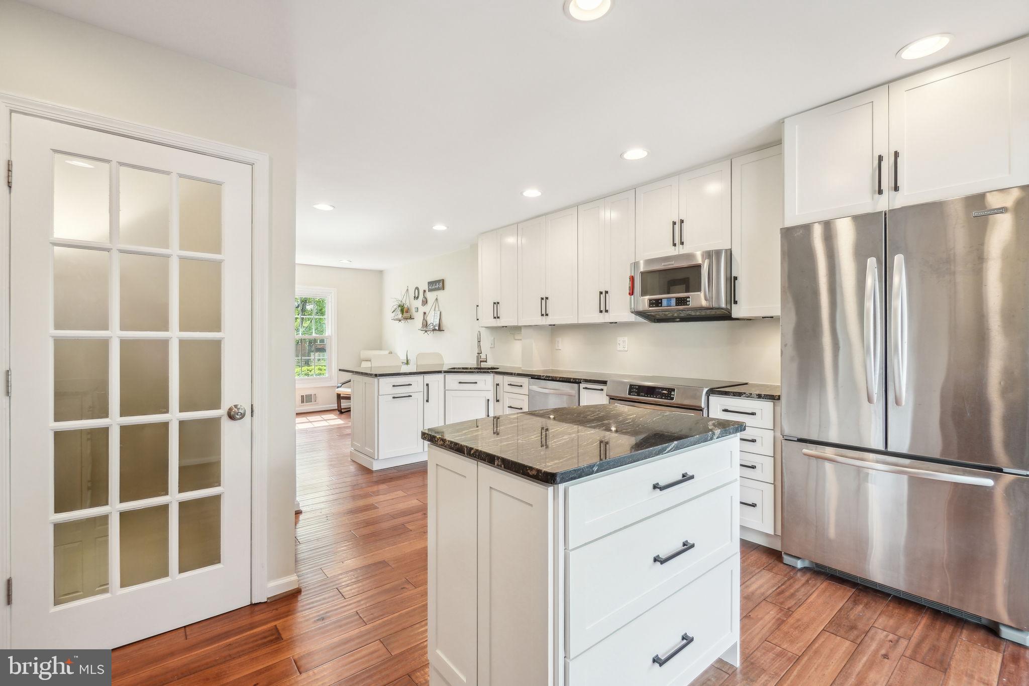 8248 Carrleigh Parkway Springfield, VA 22152 - Photo 11 of 45 a kitchen with white cabinets and stainless steel appliances