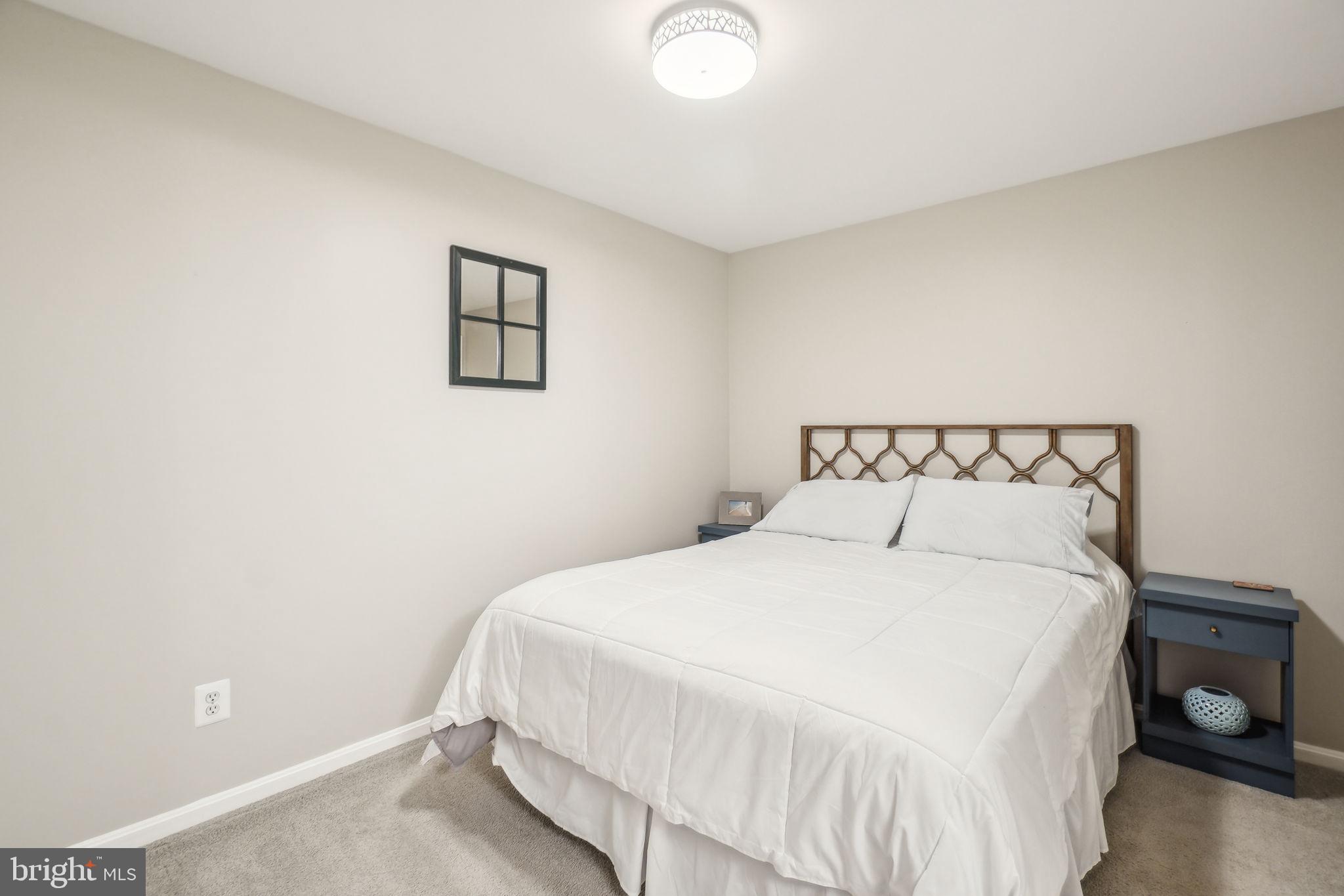 8248 Carrleigh Parkway Springfield, VA 22152 - Photo 24 of 45 a bedroom with a bed and a lamp
