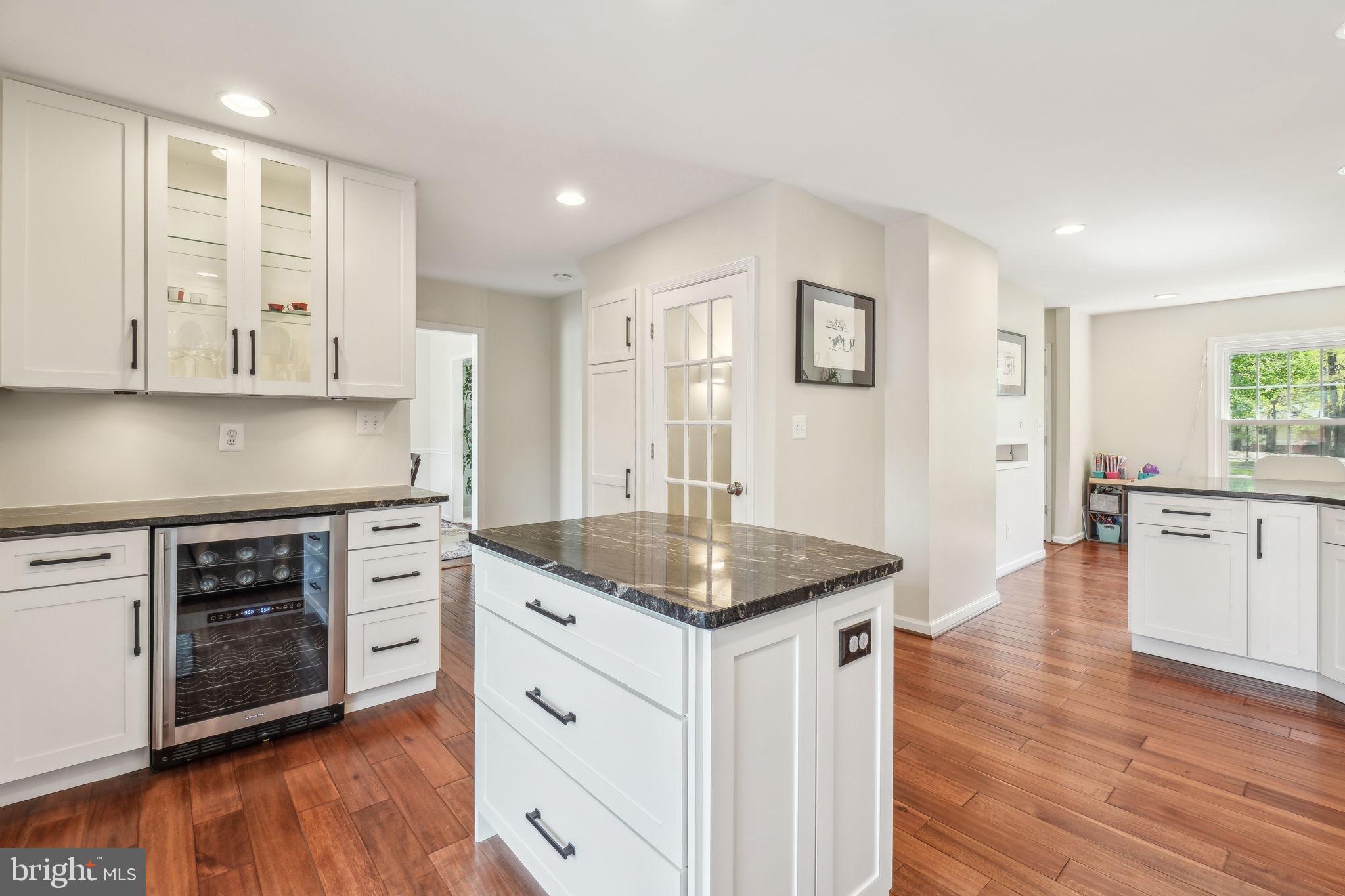 8248 Carrleigh Parkway Springfield, VA 22152 - Photo 10 of 45 a kitchen with stainless steel appliances granite countertop a stove a sink and white cabinets with wooden floor next to windows