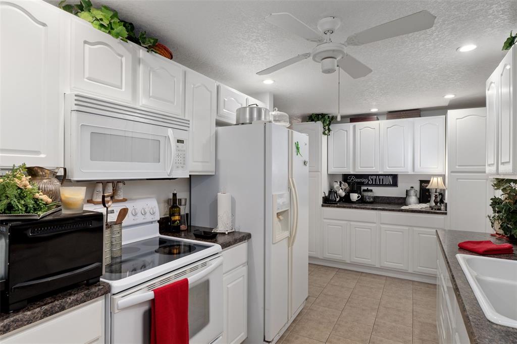 8197 Fiesta Street Brooksville, FL 34613 - Photo 15 of 49 a kitchen with stainless steel appliances a stove refrigerator sink and cabinets
