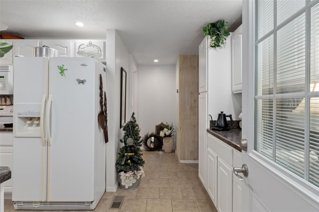 8197 Fiesta Street Brooksville, FL 34613 - Photo 18 of 49 a kitchen with white cabinets and refrigerator