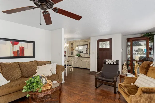 a living room with furniture and a ceiling fan