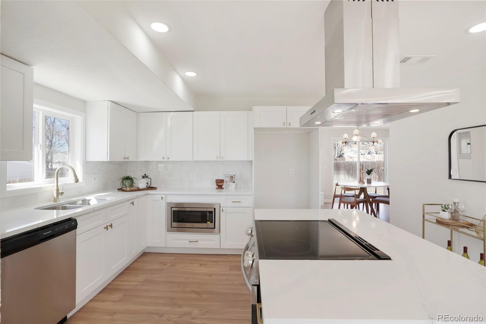 a kitchen with a sink white cabinets and white appliances