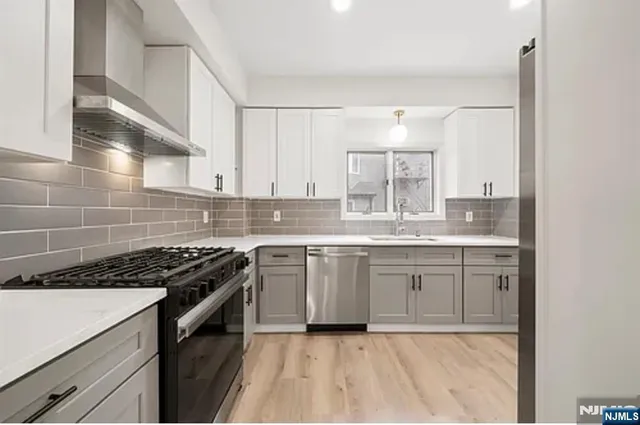 a kitchen with granite countertop a sink stove and cabinets