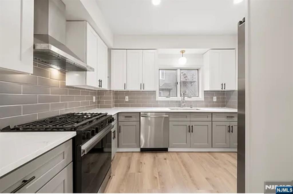 57 Byrne Street, Unit 1 Hackensack, NJ 07601 - Photo 2 of 16 a kitchen with granite countertop a sink stove and cabinets