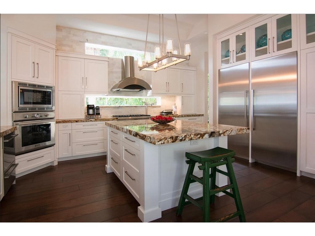 228 West Riverside Drive Jupiter, FL 33469 - Photo 4 of 6 a kitchen with kitchen island granite countertop a stove and a refrigerator