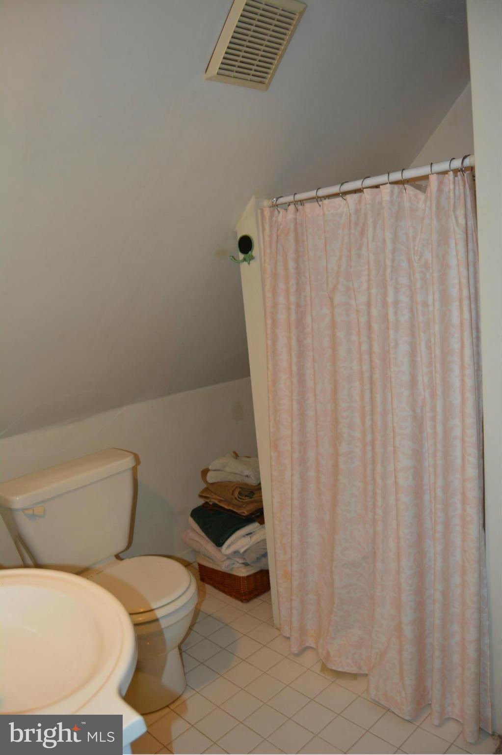 348 Ridge Road Pasadena, MD 21122 - Photo 23 of 27 a white toilet sitting next to a shower curtain