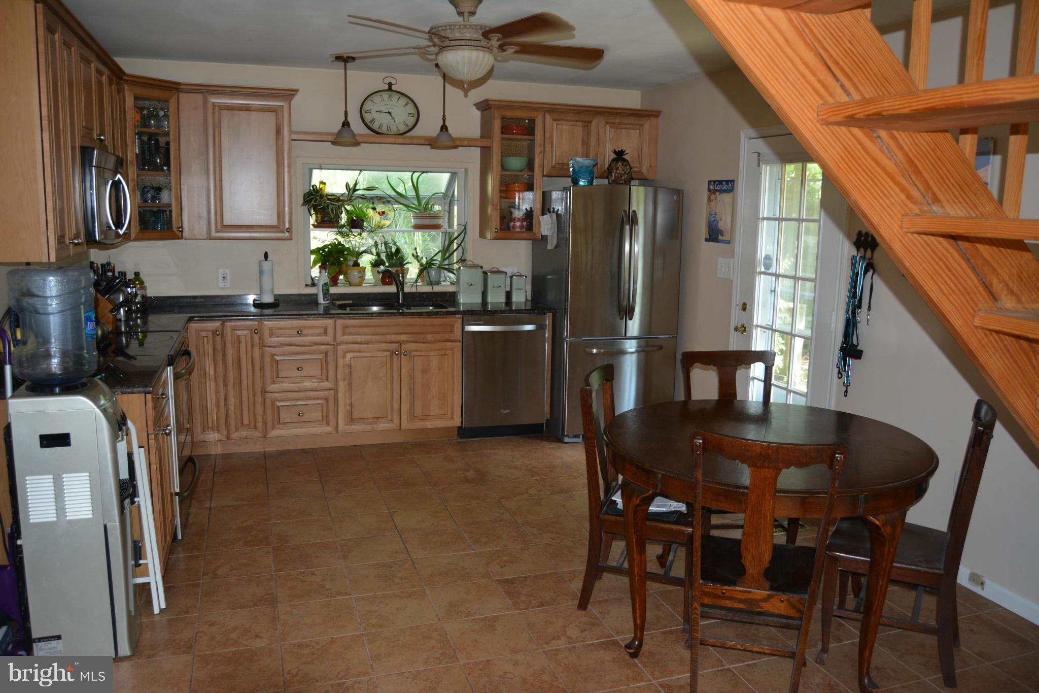 348 Ridge Road Pasadena, MD 21122 - Photo 9 of 27 a kitchen with stainless steel appliances granite countertop a refrigerator a stove a microwave oven with a dining table and chairs