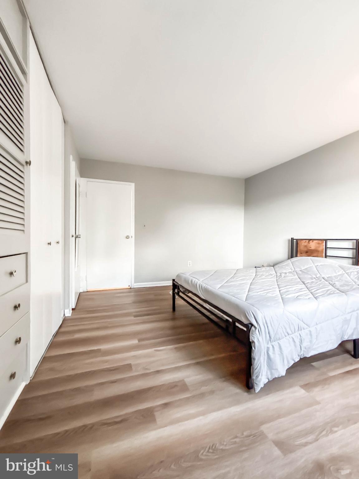 130 Slade Avenue, Unit 414 Baltimore, MD 21208 - Photo 20 of 48 a bedroom with a bed and wooden floor