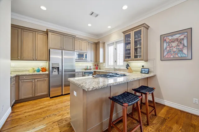 a kitchen with stainless steel appliances granite countertop a stove refrigerator and a sink
