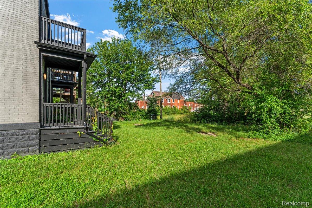 58 East Philadelphia Street Detroit, MI 48202 - Photo 23 of 24 Spacious green lot featuring mature trees, a multi-level deck, and a private second-story balcony