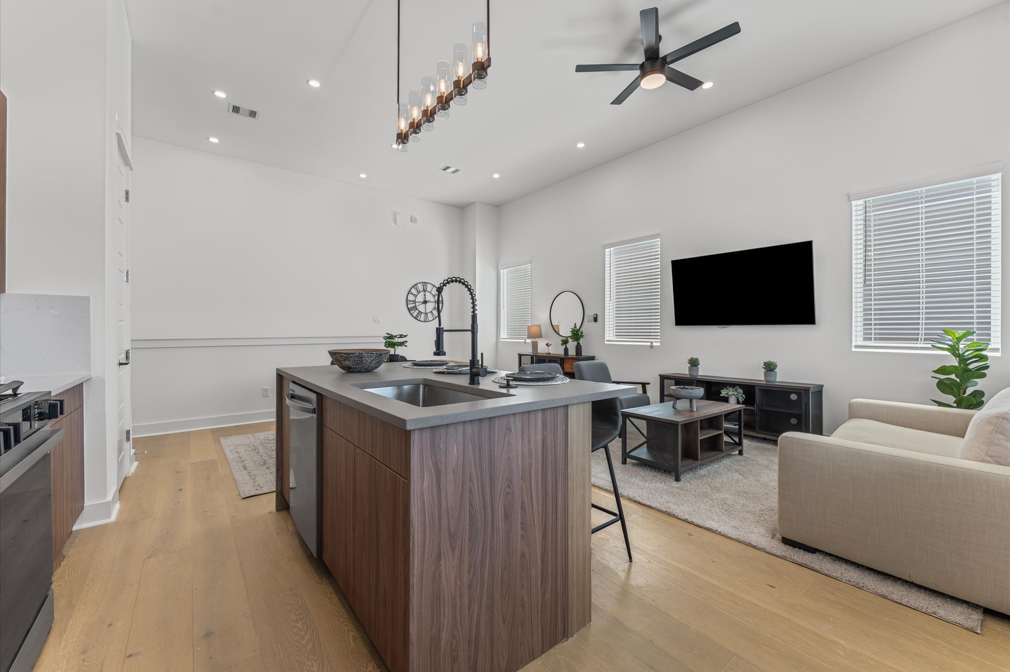 2424 Freeman Street Houston, TX 77009 - Photo 13 of 43 The heart of the second-floor open-concept living, dining, and kitchen, this spacious kitchen island features sleek modern finishes, including a one-sided cascade quartz countertop, a farmhouse sink, and stylish pendant lighting, with a built-in seating area perfect for casual breakfasts or chatting with family and friends.