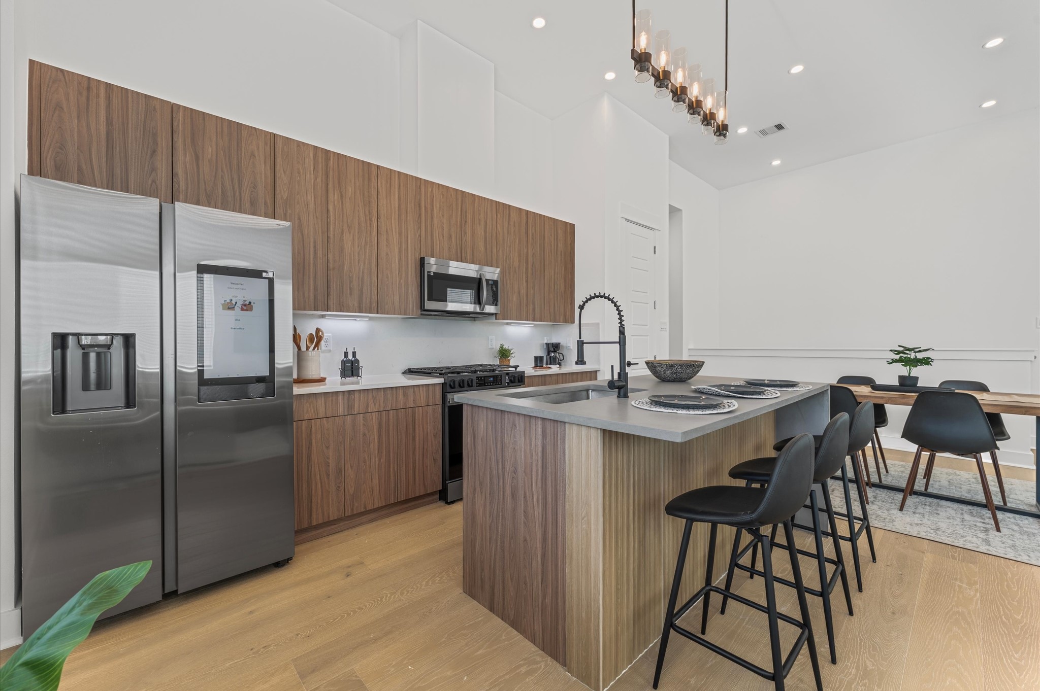 2424 Freeman Street Houston, TX 77009 - Photo 14 of 43 The heart of the second-floor open-concept living, dining, and kitchen, this spacious kitchen island features sleek modern finishes, including a one-sided cascade quartz countertop, a farmhouse sink, and stylish pendant lighting, with a built-in seating area perfect for casual breakfasts or chatting with family and friends.