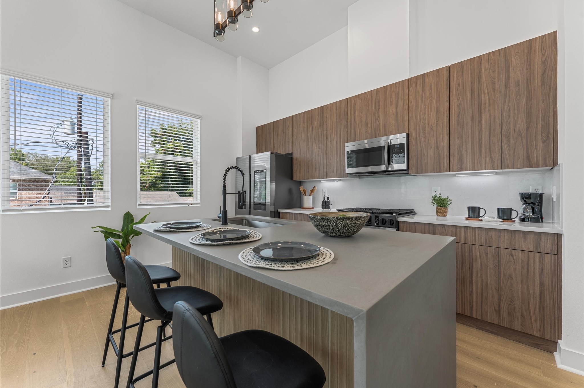 2424 Freeman Street Houston, TX 77009 - Photo 15 of 43 The heart of the second-floor open-concept living, dining, and kitchen, this spacious kitchen island features sleek modern finishes, including a one-sided cascade quartz countertop, a farmhouse sink, and stylish pendant lighting, with a built-in seating area perfect for casual breakfasts or chatting with family and friends.