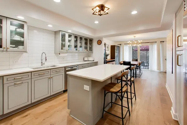 a kitchen with stainless steel appliances granite countertop a kitchen island a stove and a sink