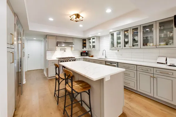 a kitchen that has a lot of cabinets in it and wooden floors