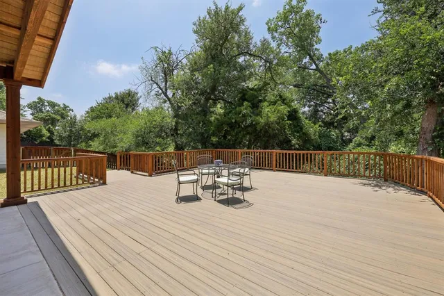 a view of a roof deck with table and chairs and wooden floor