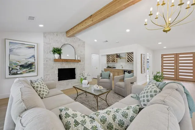 a living room with furniture a fireplace and a large window
