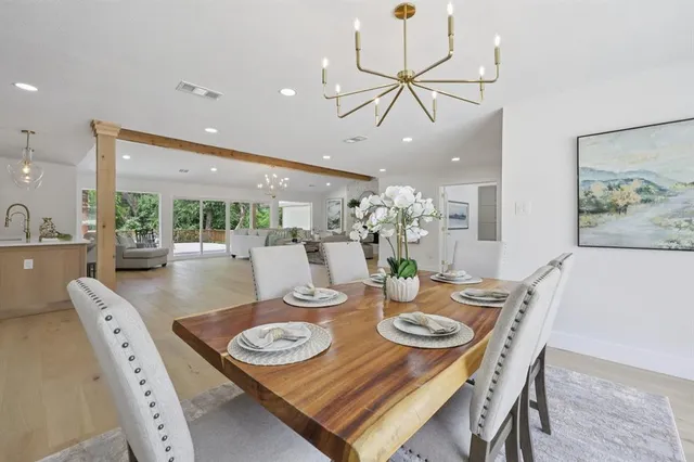 a view of a dining room with furniture a chandelier and wooden floor