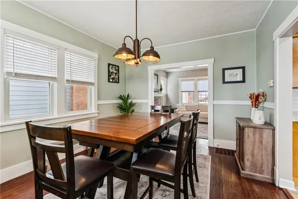a dining room with furniture a chandelier and wooden floor