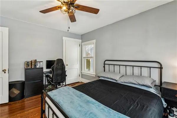 a bedroom with a bed and wooden floor