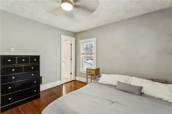 a bedroom with a bed and a lamp on dresser
