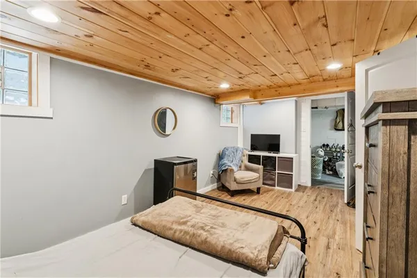 a bedroom with a bed and a flat tv screen on dresser