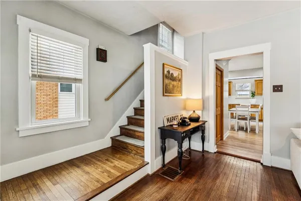 a view of a livingroom with wooden floor and furniture