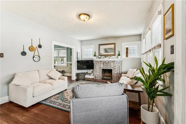 a living room with furniture a fireplace and a potted plant