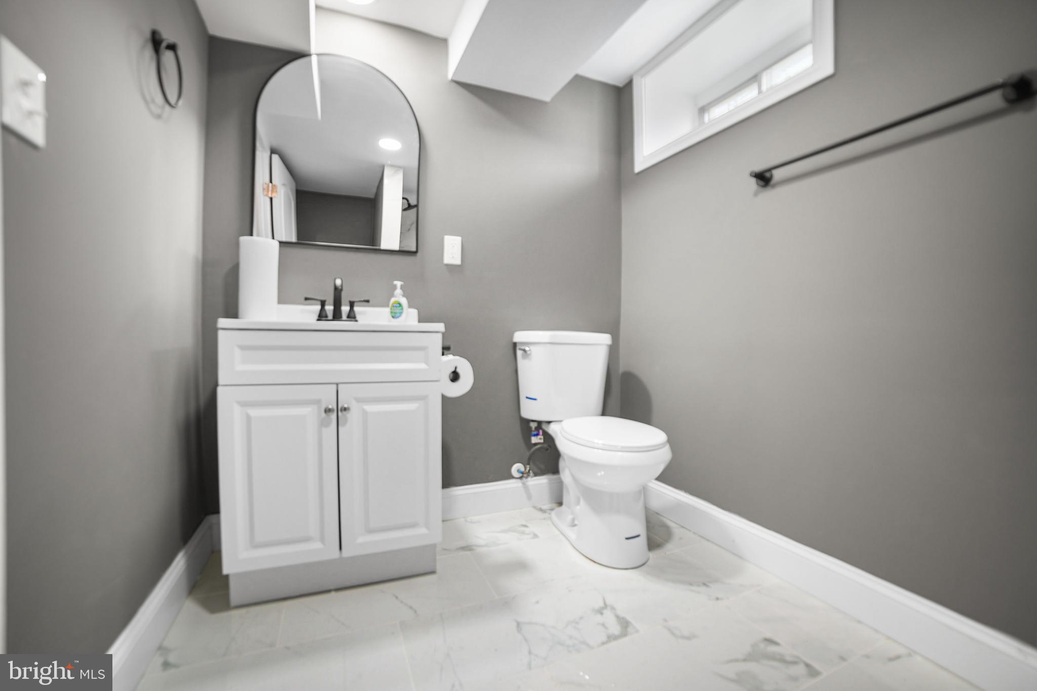 4434 Manorview Road Baltimore, MD 21229 - Photo 25 of 34 a bathroom with a toilet sink and mirror