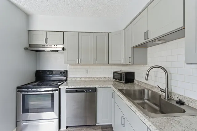 a kitchen with stainless steel appliances granite countertop a sink stove and cabinets