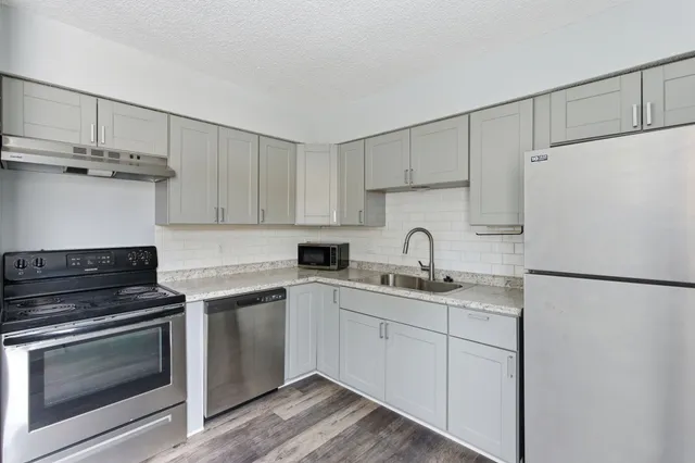 a kitchen with appliances a sink and cabinets