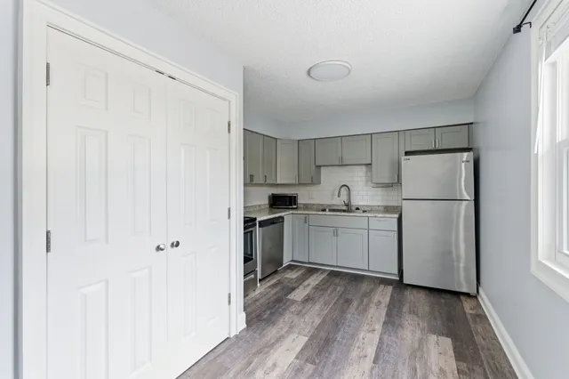 a kitchen with white cabinets and white appliances