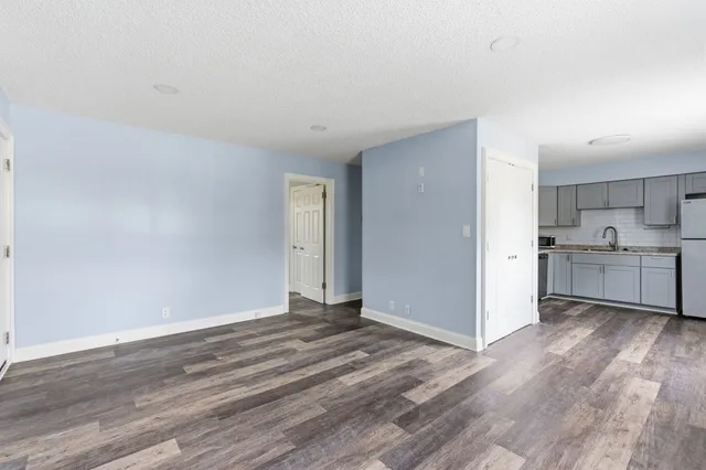 a view of a kitchen with wooden floor and a sink