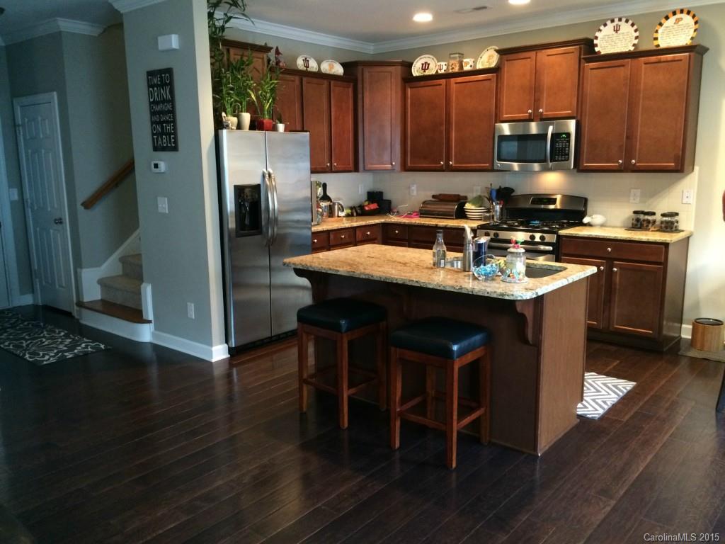 14713 Intermilan Way Charlotte, NC 28277 - Photo 5 of 16 a kitchen with stainless steel appliances granite countertop a stove top oven a refrigerator a sink and dishwasher with wooden floor