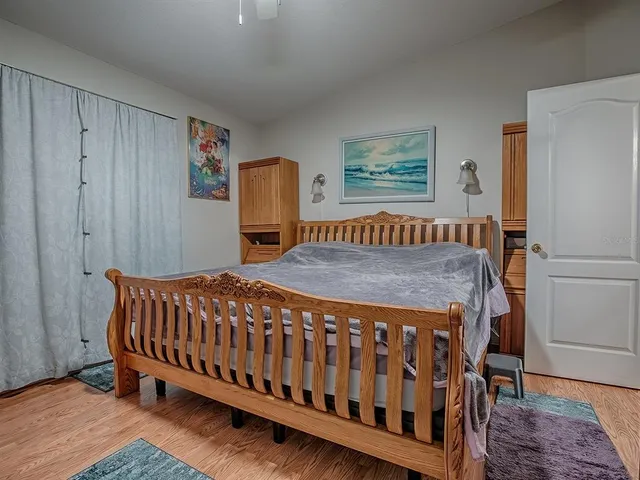 a bedroom with a bed and wooden floor