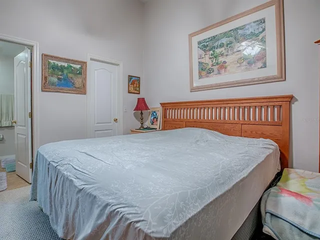 a bed sitting in a bedroom next to a painting on the wall