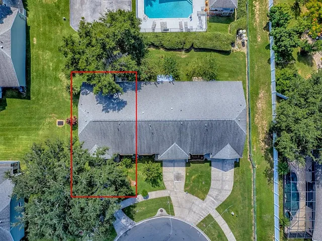 an aerial view of a house with garden space and street view