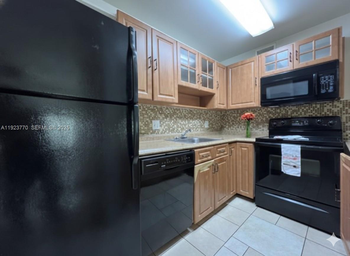 4201 West McNab Road, Unit 15 Pompano Beach, FL 33069 - Photo 5 of 18 a kitchen with stainless steel appliances granite countertop a refrigerator and a stove top oven